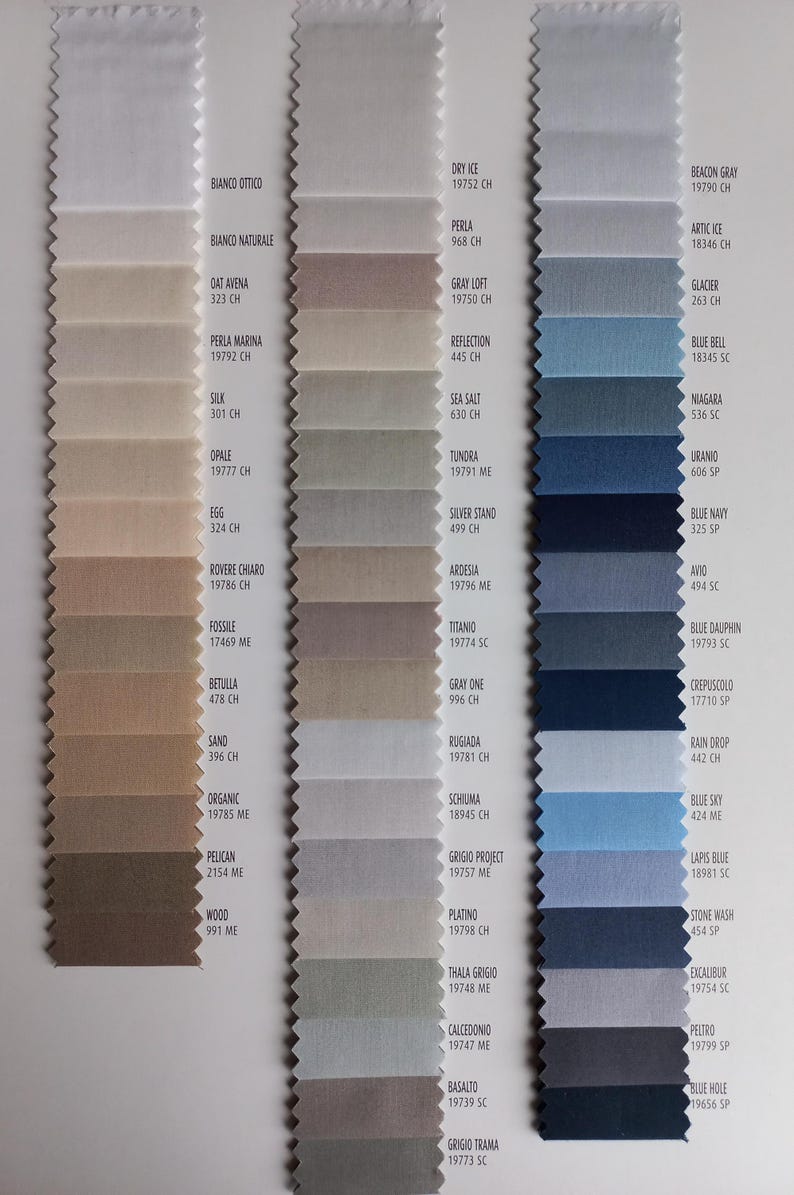 May include: A fabric sample swatch card featuring three vertical columns of rectangular textile strips with pinked edges. The swatches display a gradient of neutral, gray, and blue color tones, each labeled with specific color names and codes.