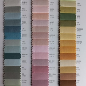 May include: A fabric swatch color chart featuring three vertical columns of pinked-edge textile samples. The columns display a gradient of blue, green, pink, rose, and brown shades, each labeled with a specific color name and alphanumeric code.