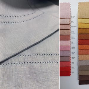 May include: A light gray linen fabric featuring a decorative hemstitch border alongside a vertical color palette display. The display includes two columns of fabric swatches in various shades of pink, red, yellow, orange, brown, and gray.