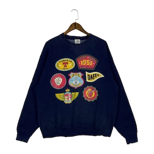 May include: Navy blue sweatshirt featuring colorful Looney Tunes character patches. Patches include Bugs Bunny, Daffy Duck, and Tasmanian Devil. The sweatshirt has a crew neck and long sleeves. The patches have text such as "Looney Tunes Animation Studio 1952".