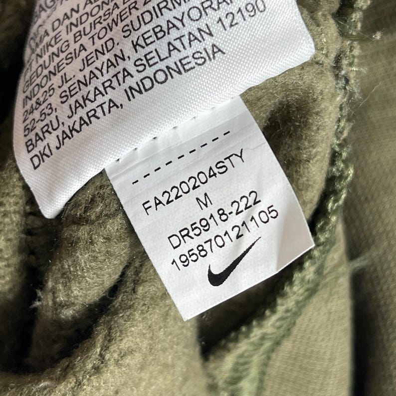 Op de afbeelding: Een witte keramische mok met een zwarte handgreep en de tekst "But First, Coffee" in een vetgedrukte, zwarte letter. De mok staat tegen een vage achtergrond, wat een gezellige setting suggereert.