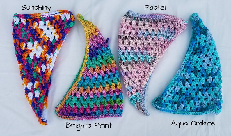 May include: Four crocheted triangle scarves in different color patterns: "Sunshine", "Brights Print", "Pastel", and "Aqua Ombre".
