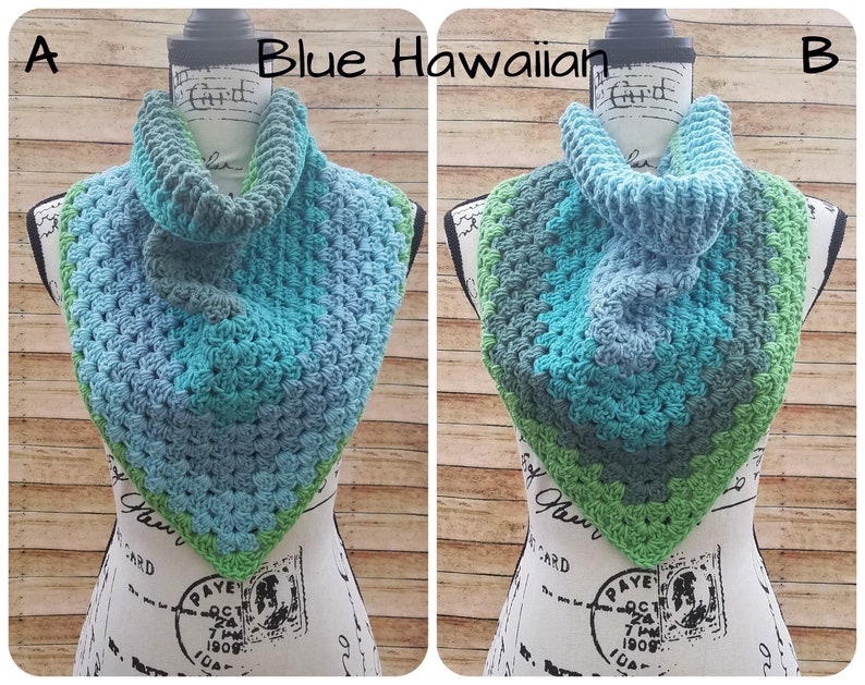 May include: Blue, green, and gray crocheted cowl with a textured stitch pattern. The cowl is displayed on a mannequin.
