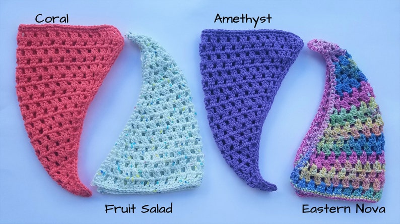 May include: Four crocheted triangle hats in different colors: coral, light blue with white flecks, purple, and a rainbow pattern. The hats are labeled "Coral", "Fruit Salad", "Amethyst", and "Eastern Nova".