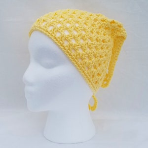 May include: A yellow crocheted headband with a tie at the back. The headband is made with a simple stitch pattern and has a loose, airy feel.