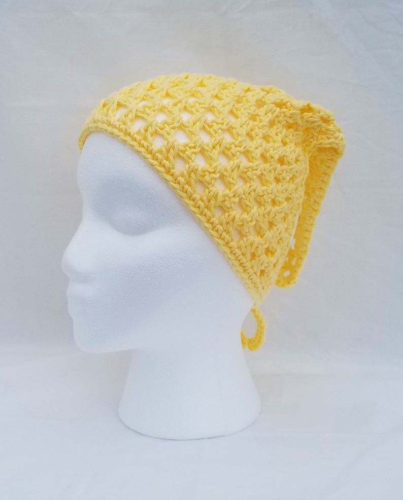May include: A yellow crocheted headband with a tie at the back. The headband is made with a simple stitch pattern and has a loose, airy feel.