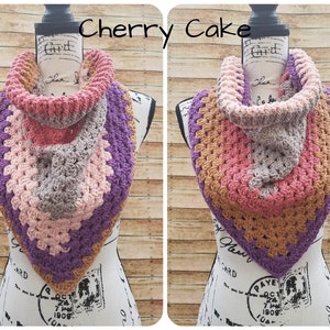 May include: A crocheted cowl in shades of brown, pink, and purple. The cowl is folded and draped over a mannequin's neck. The image is labeled "Cherry Cake" and "A" and "B".