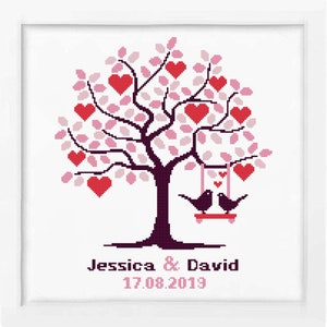 May include: A cross-stitch pattern of a pink and red heart tree with two birds on a swing. The text below the tree reads "Jessica & David 17.08.2019".