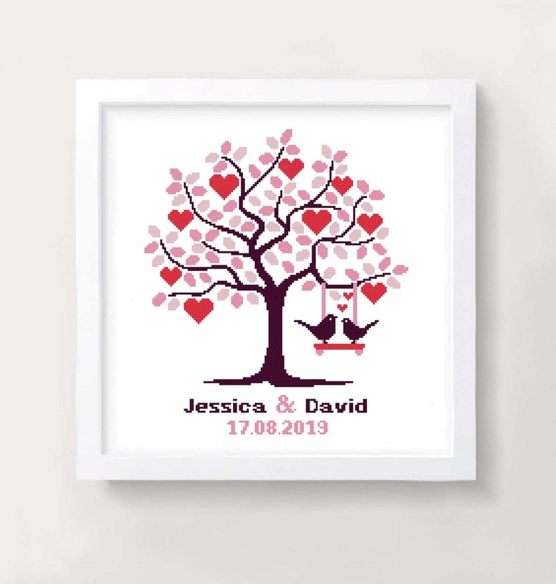 May include: A cross-stitch pattern of a pink and red heart tree with two birds on a swing. The text below the tree reads "Jessica & David 17.08.2019".
