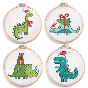May include: Four cross-stitch hoops featuring Christmas dinosaur designs. Each dinosaur is adorned with festive elements like Santa hats, scarves, Christmas trees, and wrapped gifts. The dinosaurs are in shades of green and blue, with red and white accents.