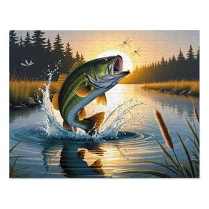 May include: A jigsaw puzzle featuring a largemouth bass leaping out of the water. The fish is green and gold, with water splashing around it. The background shows a sunset over a lake with trees and dragonflies.