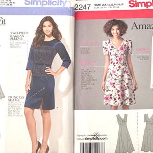 May include: Two Simplicity Amazing Fit sewing pattern envelopes, 1249 and 2247. Pattern 1249 shows a dark blue dress with raglan sleeves and princess seams. Pattern 2247 displays a floral print dress with a V-neckline and empire waist seam.
