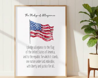 May include: A framed wall art print featuring the text The Pledge of Allegiance at the top, a watercolor illustration of a waving American flag in the center, and the full text of the Pledge of Allegiance printed in black ink below the flag.