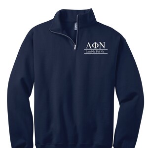 Könnte beinhalten: Marineblaues Sweatshirt mit Viertelreißverschluss, weißen griechischen Buchstaben und dem Text "Lambda Phi Nu". Das Sweatshirt hat einen hohen Kragen und einen silbernen Reißverschluss. Der Text ist mittig auf der Brust platziert.