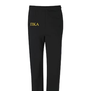 May include: Black sweatpants with a yellow embroidered "PIKA" on the left leg.