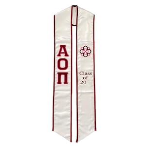 May include: White graduation stole with maroon trim and the letters "AOP" in maroon. The stole also features a pink and maroon flower design and the text "Class of 20".