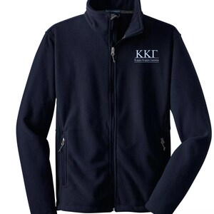 May include: Navy blue fleece jacket with a full zipper and two side pockets. The jacket features the letters "KKΓ" and the words "Kappa Kappa Gamma" in white on the upper chest. The jacket has a high collar.