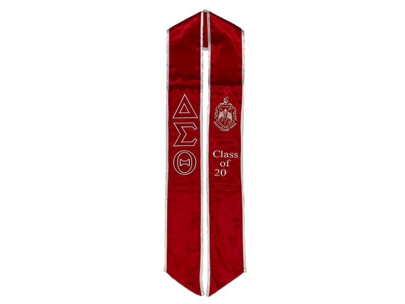 May include: Red graduation sash with white piping and gold embroidery. The sash features the Greek letters Delta Sigma Theta and the text "Class of 20".