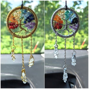 May include: Two car charms featuring a wire tree of life design with colorful gemstones. The charms are suspended from a silver chain with three crystal-shaped pendants.