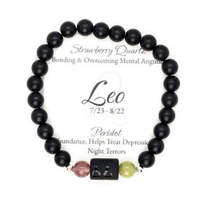 May include: Black beaded bracelet with a silver charm featuring the zodiac sign Leo and the text "Leo 7/23-8/22". The bracelet also includes three gemstone beads: strawberry quartz, peridot, and a pink stone. The card reads "Strawberry Quartz Bonding & Overcoming Mental Anguish Leo 7/23-8/22 Peridot Abundance, Helps Treat Depression Night Terrors".