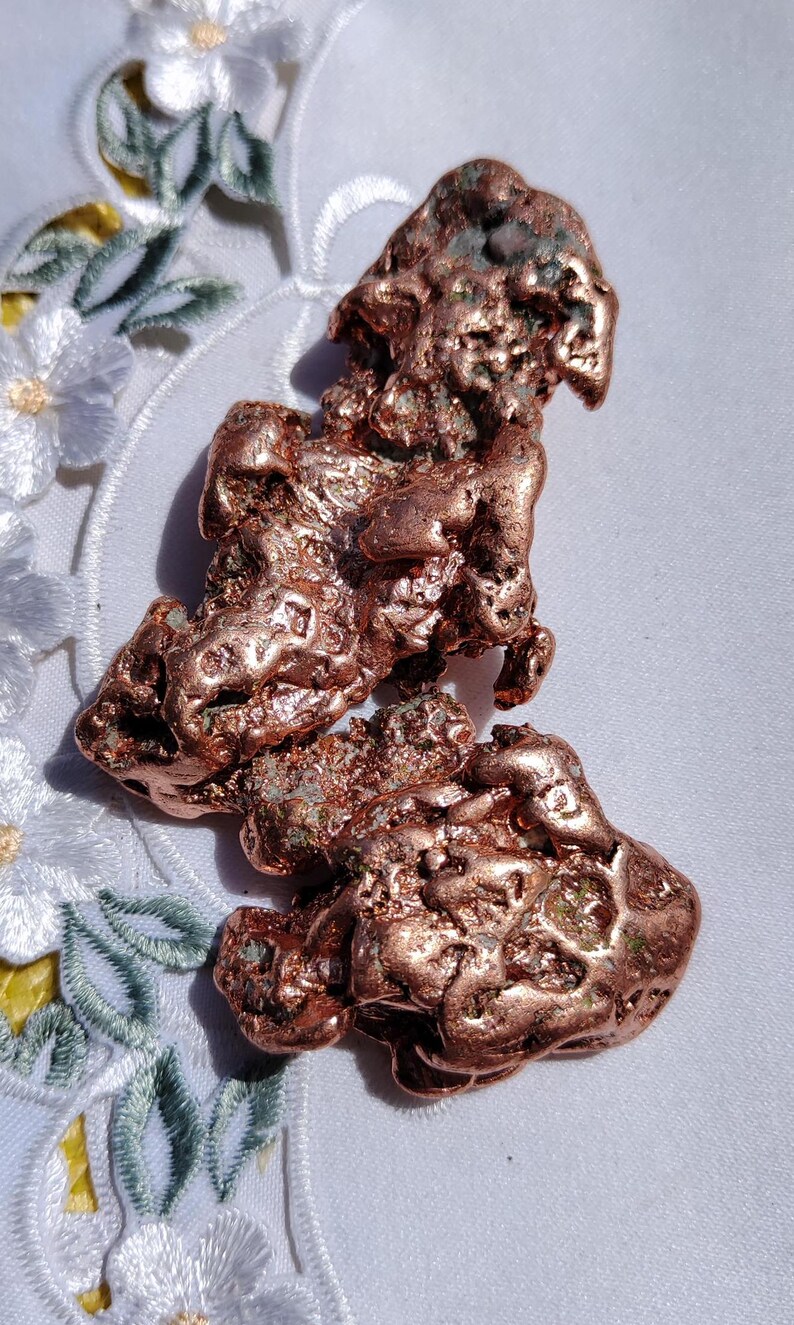 May include: A large, rough piece of copper ore with a reddish-brown color and a green patina. The ore is irregularly shaped and has a textured surface.