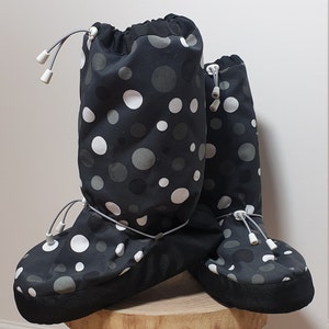 May include: A pair of black and white polka dot boot covers with a drawstring closure. The boot covers are made of a water-resistant material and are perfect for keeping your feet warm and dry in the winter.