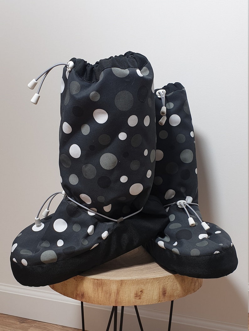 May include: A pair of black and white polka dot boot covers with a drawstring closure. The boot covers are made of a water-resistant material and are perfect for keeping your feet warm and dry in the winter.