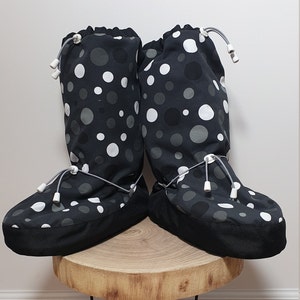 May include: A pair of black and white polka dot boot covers with a drawstring closure. The boot covers are made of a soft, comfortable fabric and are perfect for keeping your feet warm and dry.