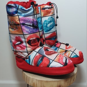 May include: Red and white slipper boots with a colourful print of lips. The boots have a drawstring closure at the top.