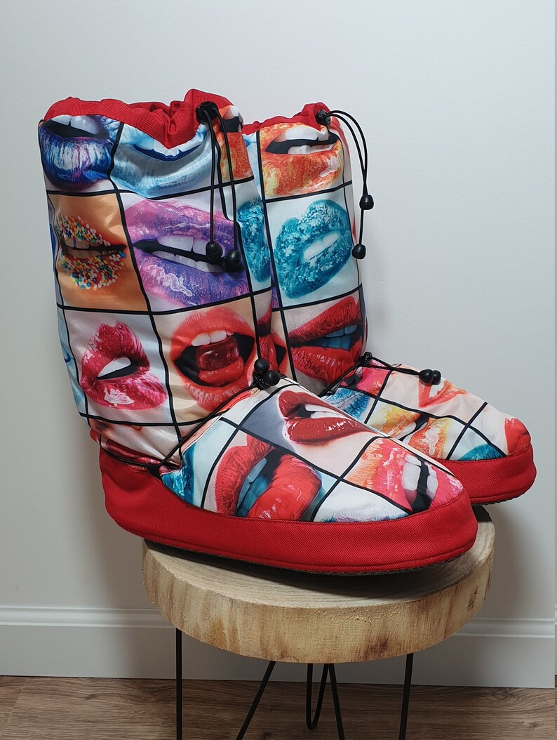 May include: Red and white slipper boots with a colourful print of lips. The boots have a drawstring closure at the top.