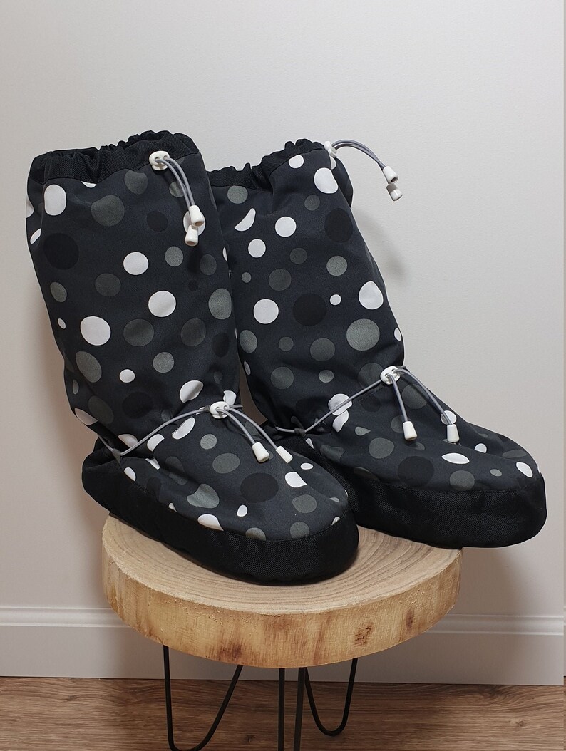 May include: A pair of black and white polka dot boot covers with a drawstring closure. The boot covers are made of a soft, water-resistant material and are perfect for keeping your feet warm and dry in cold weather.