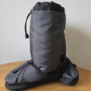 May include: Black and white polka dot boot covers with a drawstring closure.