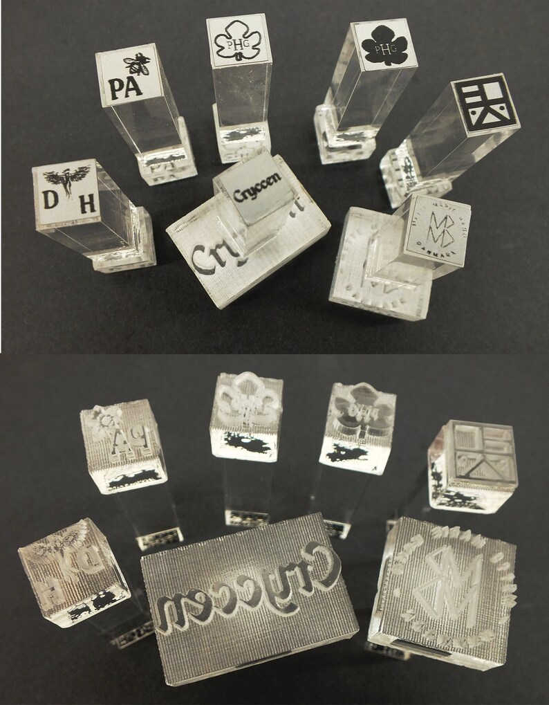 以下が含まれることがあります： 様々なデザインとテキストが施された、透明なアクリルスタンプのコレクション。イニシャル、ロゴ、または「Cryccen」のテキストが表示されているスタンプもあります。スタンプは長方形で、透明なハンドルが付いています。