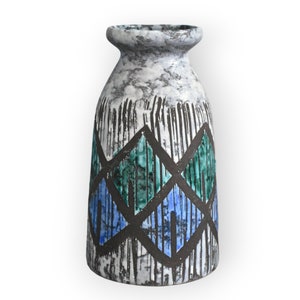 Może przedstawiać: Ceramiczny wazon z geometrycznym wzorem w kolorze białym, szarym i czarnym. Wzór zawiera niebieskie i zielone romby.