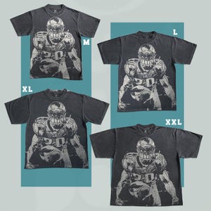 May include: Four dark gray t-shirts with a distressed graphic of a football player in a helmet and pads. Sizes include M, L, XL, and XXL. The shirts are displayed against a teal background.