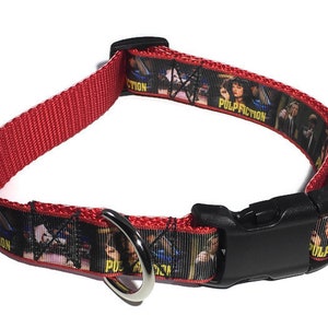 May include: Red dog collar with a black plastic buckle and a silver D-ring. The collar has a black and white ribbon with a print of characters from the movie "Pulp Fiction" and the text "Pulp Fiction".
