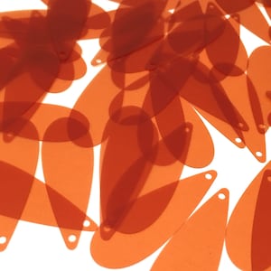 Peut inclure: Un tas de paillettes orange en forme de larme. Les paillettes sont translucides et ont une finition brillante.