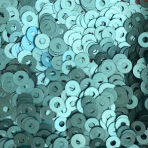 May include: A large pile of teal-coloured metal washers.