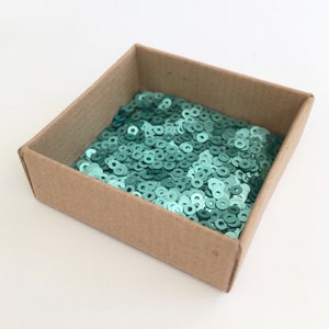3mm circle sequins in a recycled cardboard box.