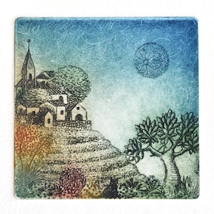 May include: A square art print depicting a village scene under a moonlit sky. The artwork features a church, houses, trees, and a full moon. The color palette includes blues, greens, and earth tones, creating a serene landscape.