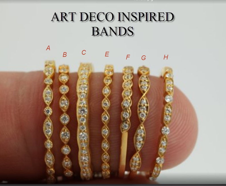 Pu&ograve; includere: Una collezione di fasce dorate ispirate all'Art D&eacute;co, ognuna ornata di pietre preziose scintillanti. Le fasce presentano vari design, tra cui forme alternate e file continue di pietre. Il testo "ART DECO INSPIRED BANDS" &egrave; visualizzato in alto.