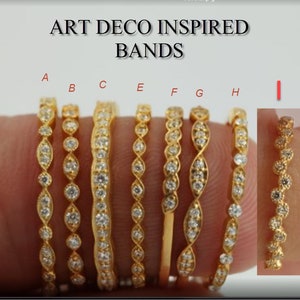 Pu&ograve; includere: Una collezione di anelli in oro ispirati all'Art D&eacute;co, ognuno con design intricati e gemme chiare. Gli anelli variano nello stile, mostrando diversi motivi e disposizioni di pietre. L'immagine include il testo "ART DECO INSPIRED BANDS".