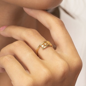Op de afbeelding: Een gouden ring met een ontwerp van sterren die uit de band zijn gesneden.