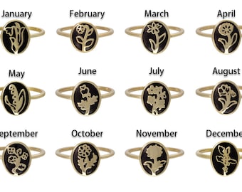 May include: Twelve gold rings with black enamel, each featuring a different flower design. The rings are labeled with the months of the year, January through December.
