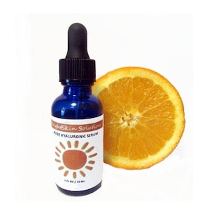 May include: A blue glass bottle of BrightSkin Solutions Pure Hyaluronic Serum with a black dropper and a white label featuring a sun design. A slice of orange is next to the bottle. The bottle contains 1 fl oz / 30 ml.