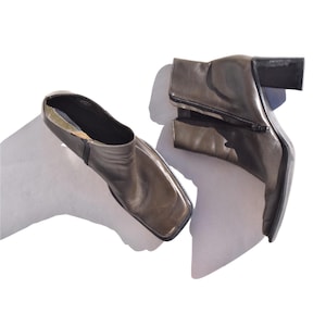 May include: A pair of black leather ankle boots with a square toe and a block heel.