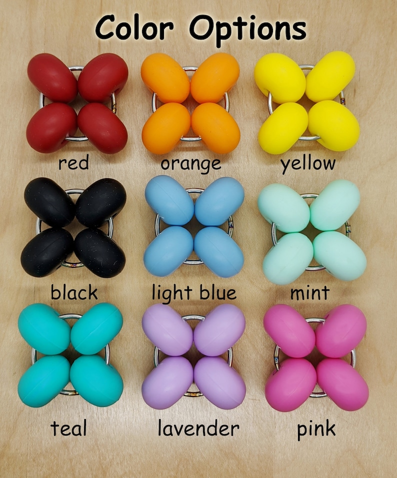 Puede incluir: Opciones de color para un juguete sensorial de silicona. El juguete tiene forma de estrella de cuatro puntas con bordes redondeados. Los colores son rojo, naranja, amarillo, negro, azul claro, menta, turquesa, lavanda y rosa.