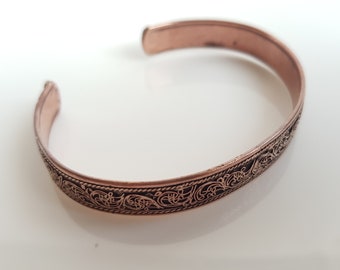 Handgjort armband/manschett i ren koppar. Handskuren blommig Nepal-konst.