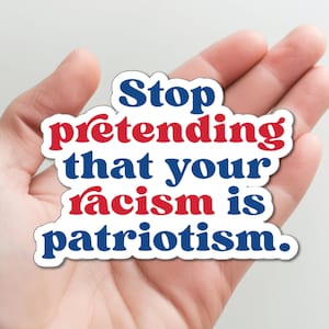 May include: A sticker with the text "Stop pretending that your racism is patriotism." The text is in blue and red letters with a white background.
