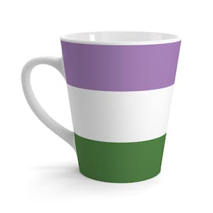 Puede incluir: Una taza de café con leche de cerámica blanca con un asa curva. La taza está decorada con tres franjas horizontales: una franja superior de lavanda, una franja central blanca y una franja inferior verde oscuro. La taza está vacía.